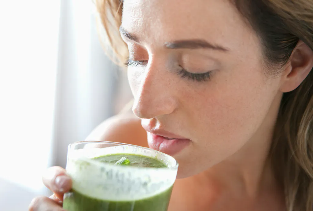 Kobieta pijąca smoothie, aby mieć więcej energii Kobieta pijąca smoothie, aby mieć więcej energii