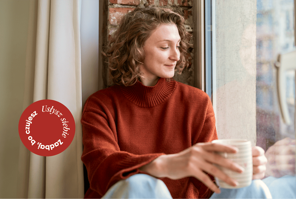Kobieta siedząca przy oknie z herbatą, troszcząca się o siebie