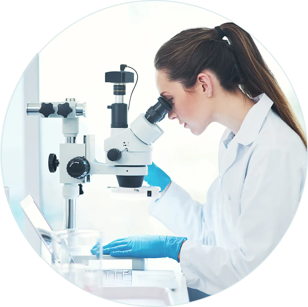Kobieta w laborarorium badająca szczep pod mikroskopem